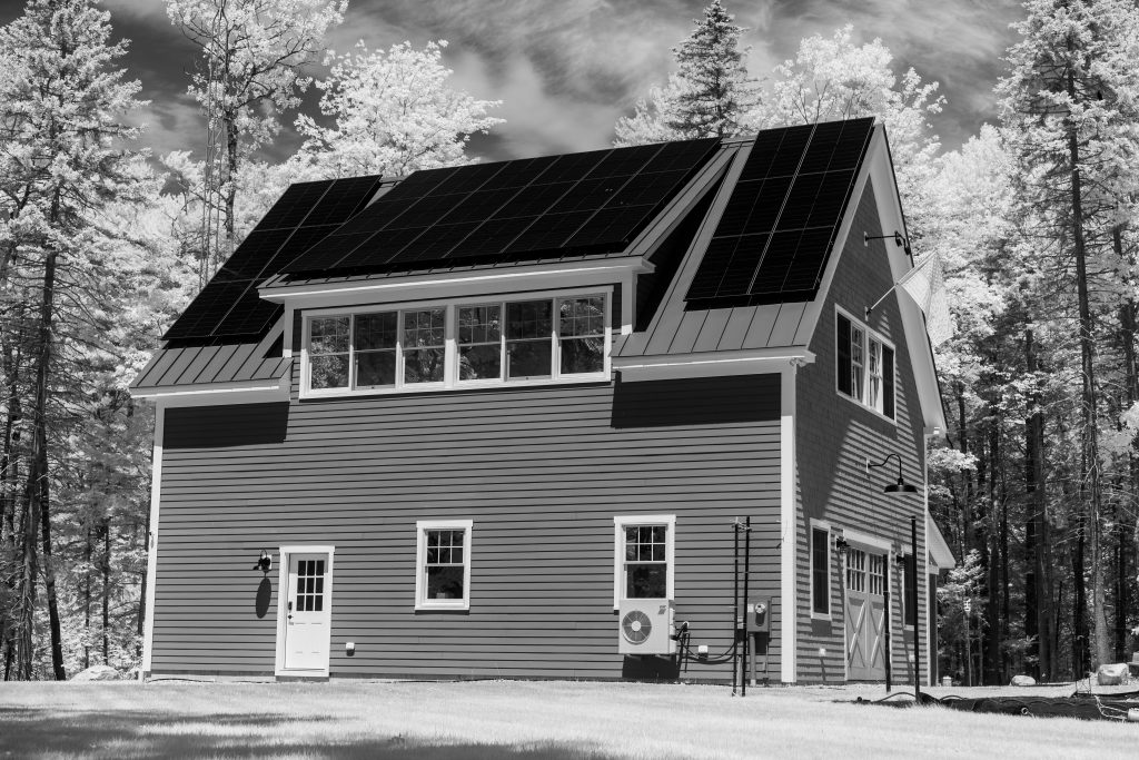 Maison moderne avec panneaux solaires en forêt