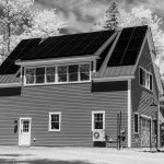 Maison moderne avec panneaux solaires en forêt