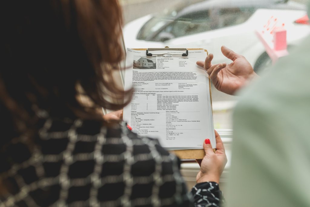 Agent immobilier examinant documents propriété avec client