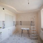 Spacious kitchen under renovation with ladder and tools, showcasing a fresh new design. Cuisine spacieuse en rénovation avec échelle et outils, présentant un design neuf et frais.