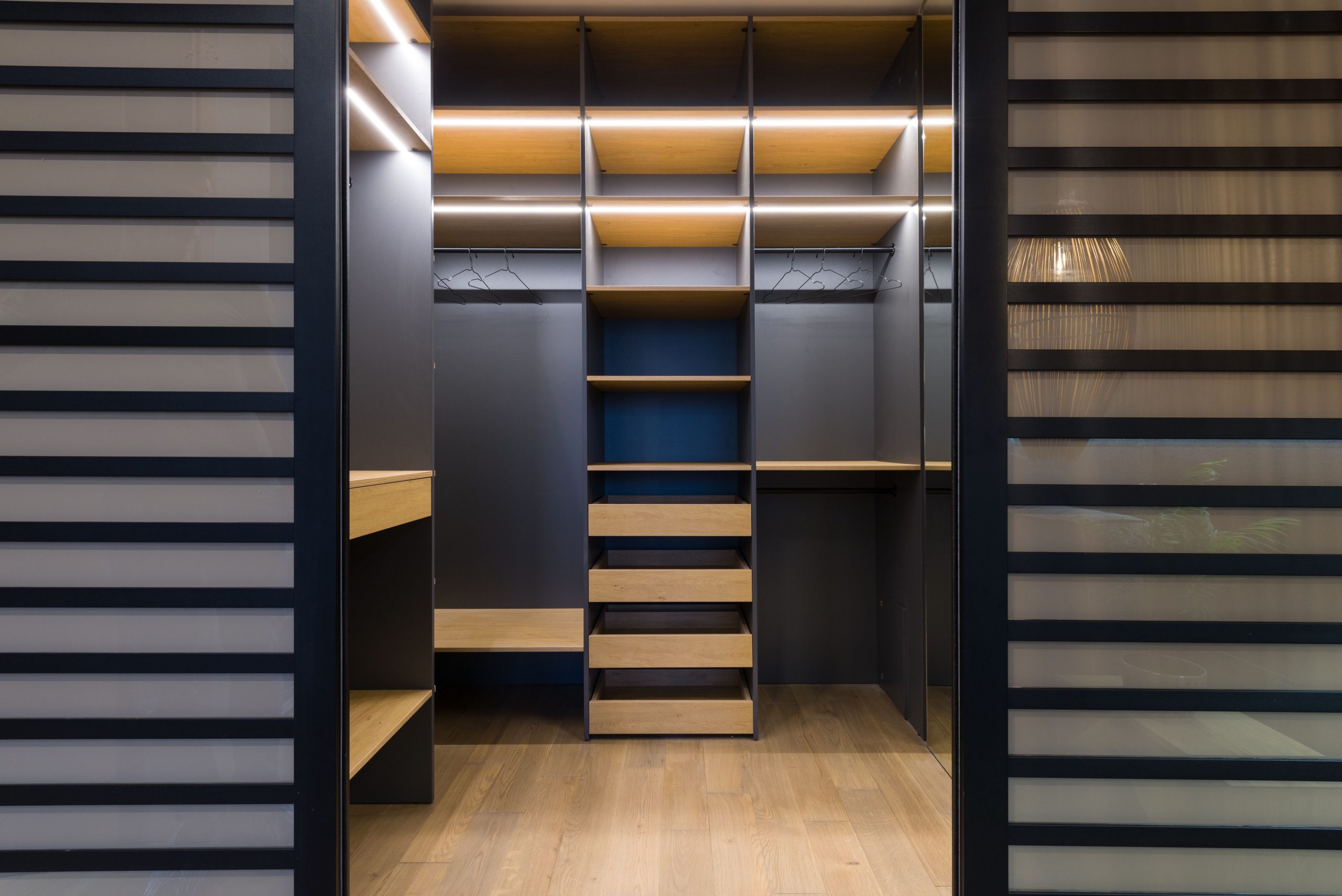 Dressing luxe avec étagères bois et éclairage