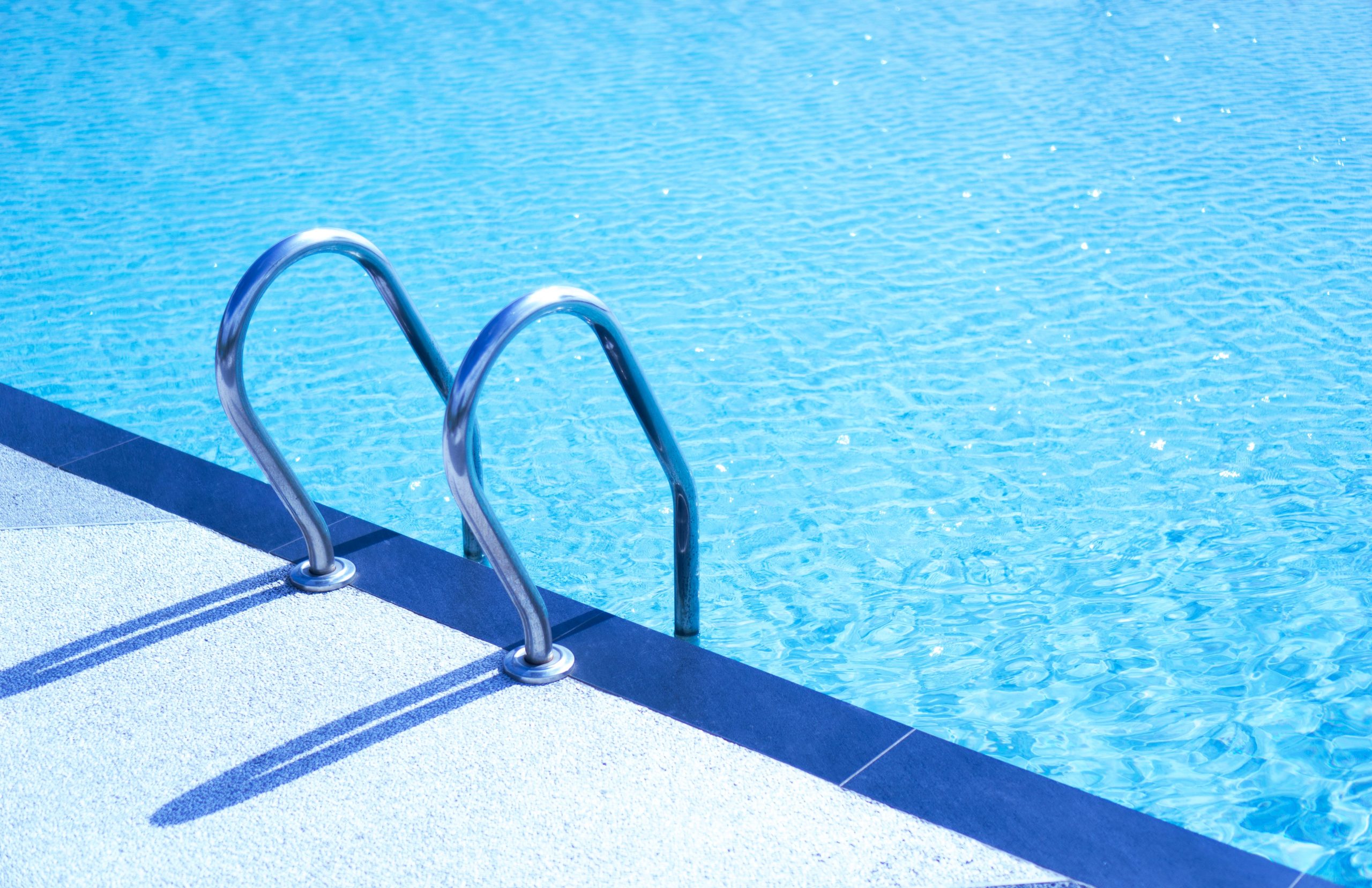 Escalier métallique menant dans une piscine turquoise