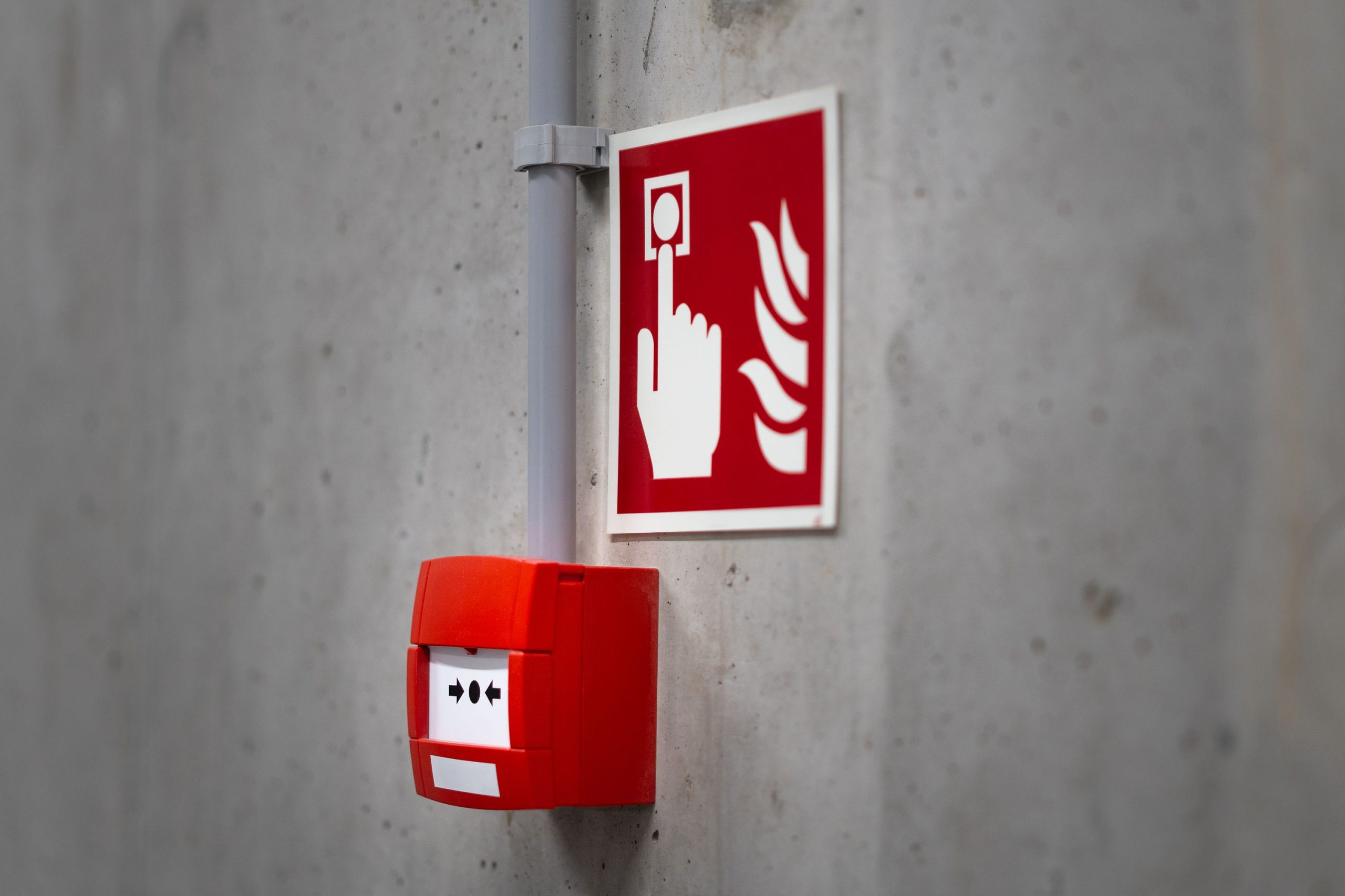 Bouton alarme incendie rouge mur béton