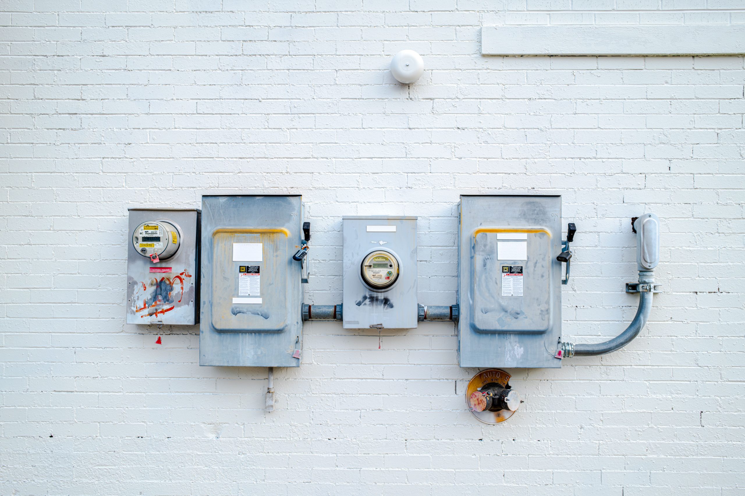 Boîtes électriques et compteurs sur mur blanc