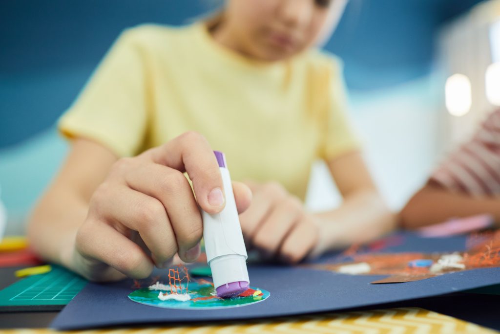 Enfant utilisant de la colle pour un projet créatif
