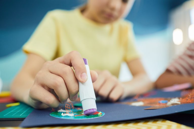 Enfant utilisant de la colle pour un projet créatif