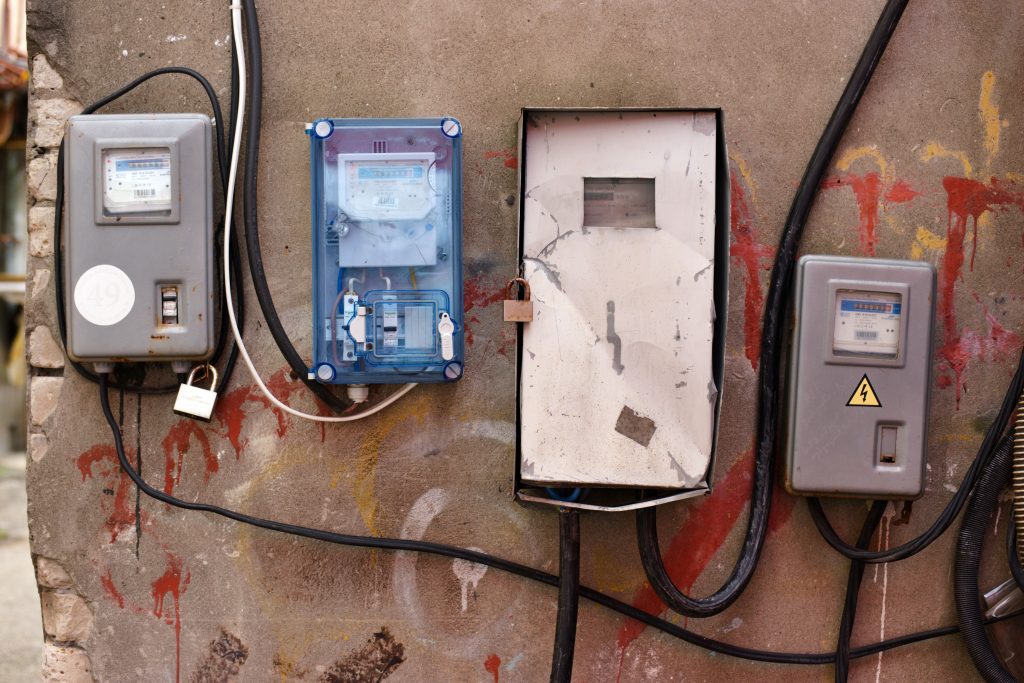 Compteurs électriques sur mur couvert de graffitis