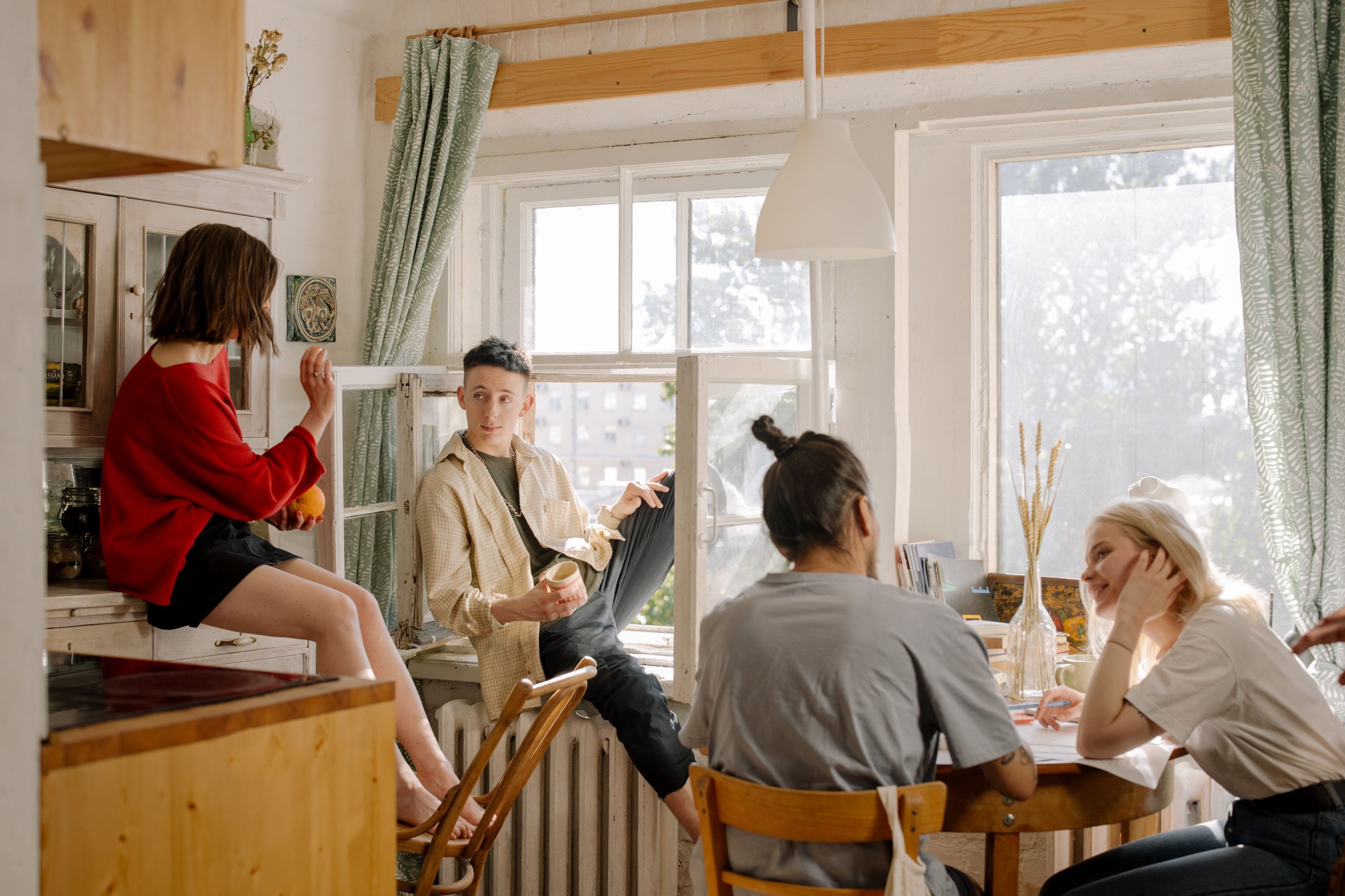 Jeunes amis discutant dans une cuisine lumineuse