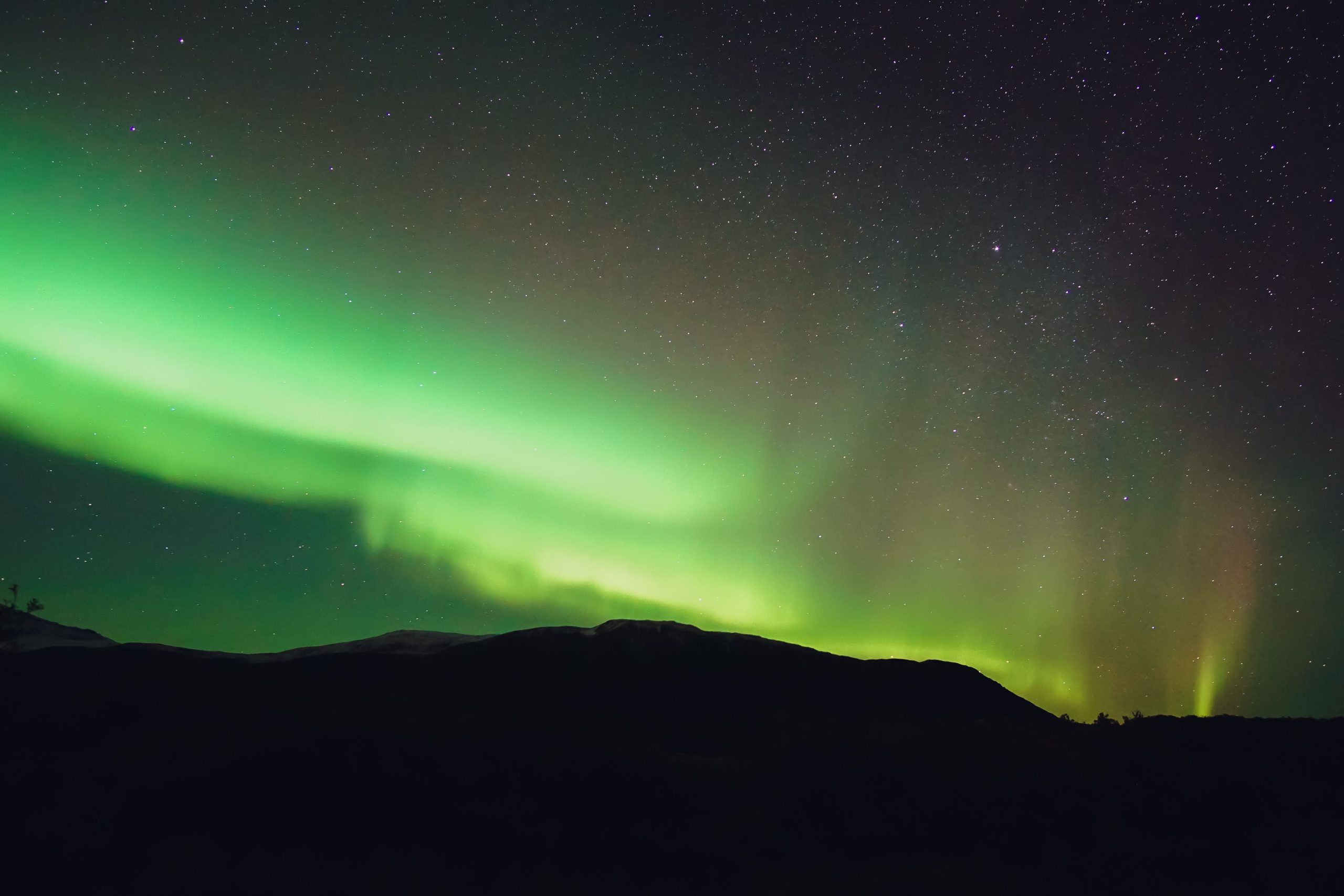 Lumières polaires brillantes au-dessus des montagnes