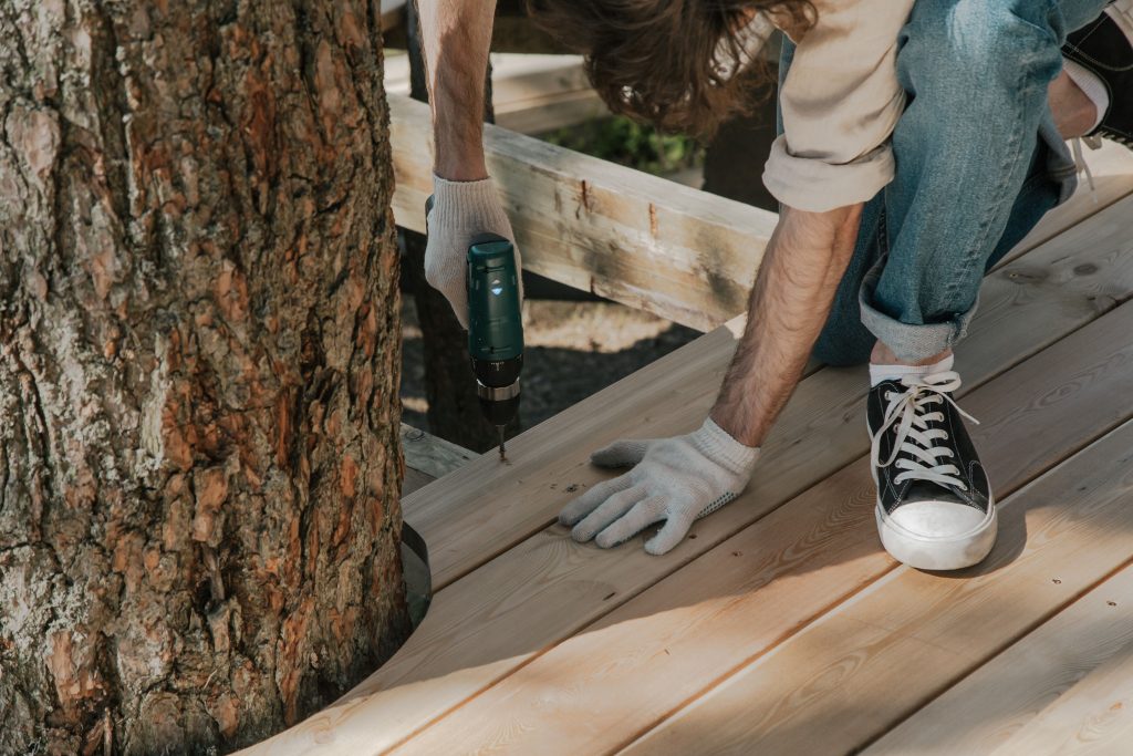 Ouvrier perçant des planches bois terrasse