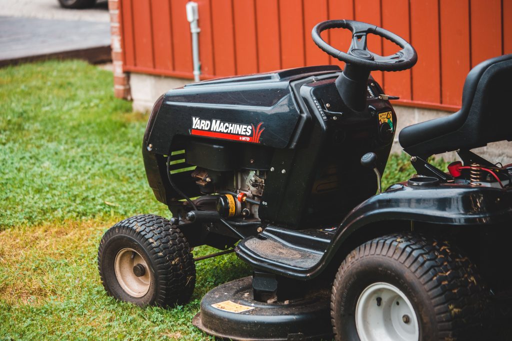 Tracteur tondeuse noire sur pelouse herbeuse