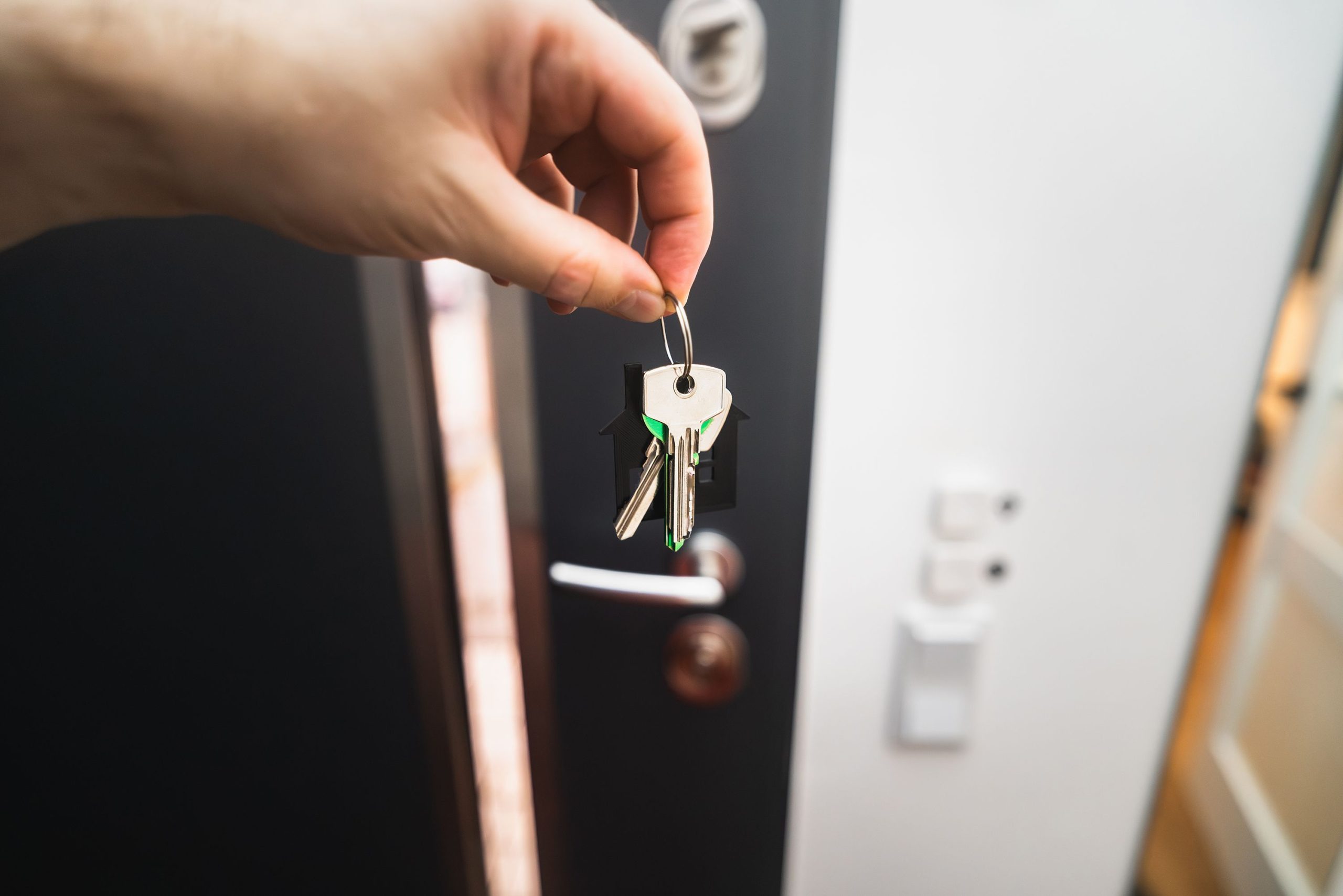 Main tenant clés devant porte neuve