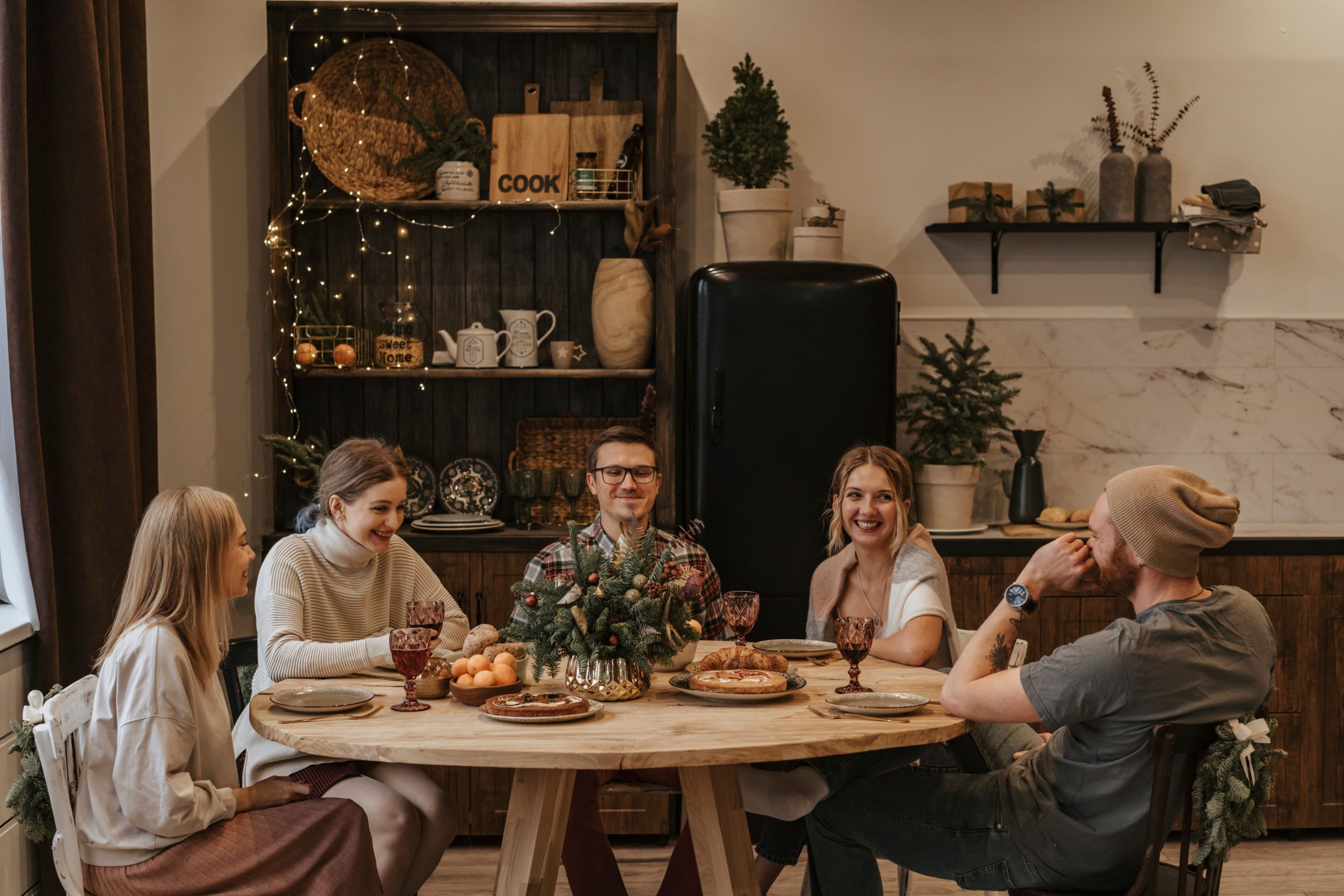 Famille et amis réunis autour table en bois