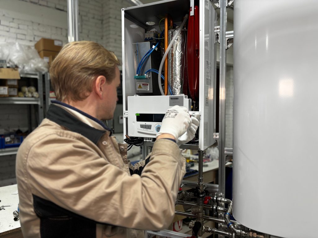 Technicien réparant un chauffe-eau en atelier