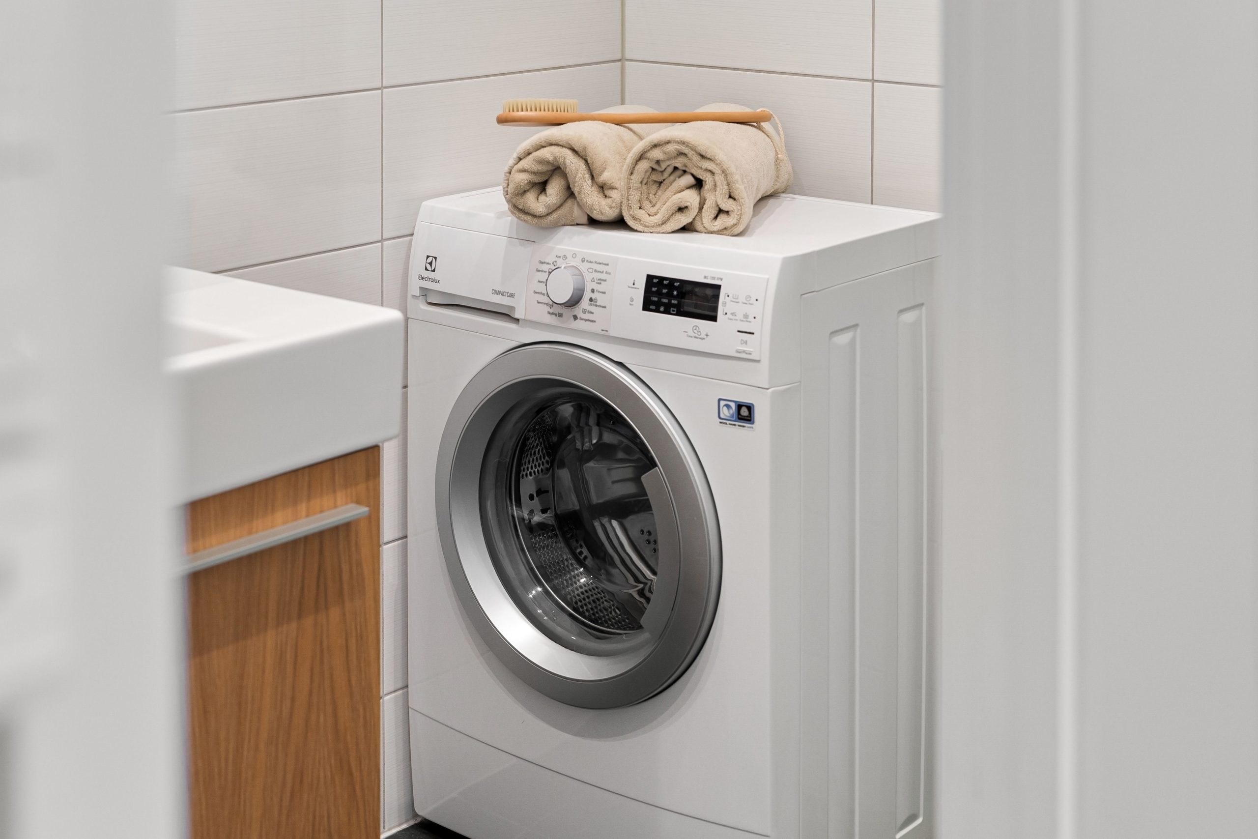 Buanderie épurée avec lave-linge blanc et serviettes