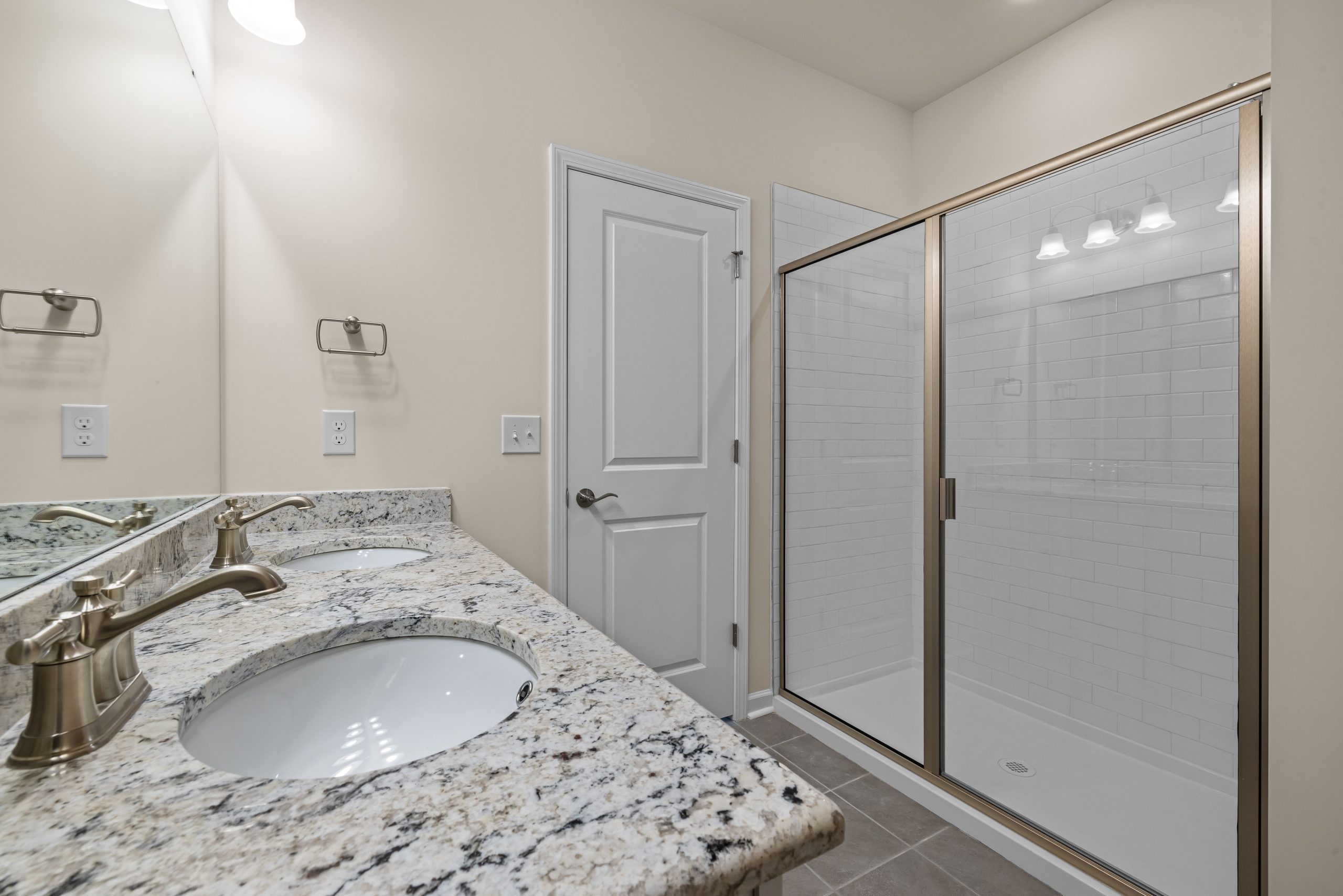 Douche spacieuse avec portes vitrées et comptoirs granit
