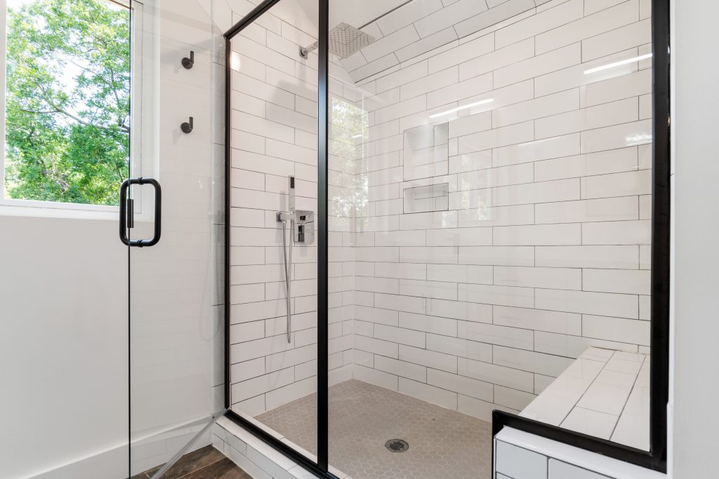 Douche moderne avec portes vitrées et carrelage lumineux